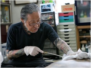 Le maître Horiyoshi durant une séance de tatouage